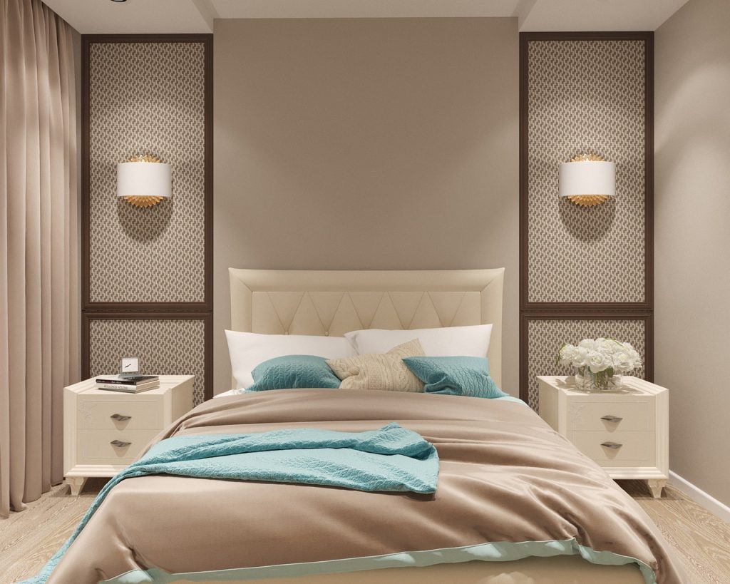 Ein modernes Schlafzimmer in Pastellfarben (beige, mintgrün, braun und weiß). Der Fußbodenbelag besteht aus einem Holzboden mit moderner Struktur. Das Bett ist mit weißen, mintfarbenen und einem beigefarbenen Kissen dekoriert. Die Decke ist hellbraun. Links und rechts befinden sich Nachttische mit je zwei Schubladen. Auf dem linken Nachttisch befinden sich drei Bücher und ein rechteckiger Wecker, auf dem rechten Nachttisch befindet sich eine niedrige runde Vase mit weißen Rosen.